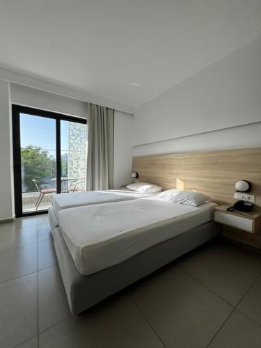 科斯镇凯瑟琳酒店 的一间卧室设有一张大床和一个大窗户