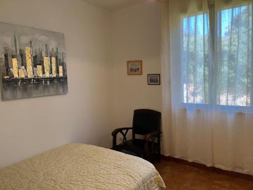 菲加里Casa Minnana的一间卧室设有一张床、一个窗口和一把椅子