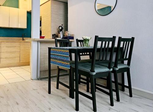 里昂Le Canut Duviard - proche métro Croix-Rousse的餐桌、两把椅子和厨房