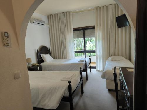 塞洛里库达贝拉米拉塞拉酒店的酒店客房设有两张床和窗户。