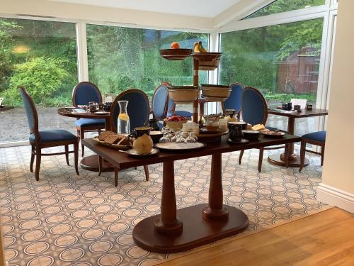 基拉尼格任菲亚乡间别墅酒店的客房设有桌椅和大窗户。
