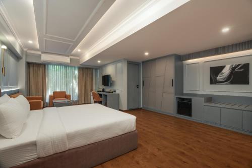 班加罗尔Pelican Inn的卧室配有白色的床和电视