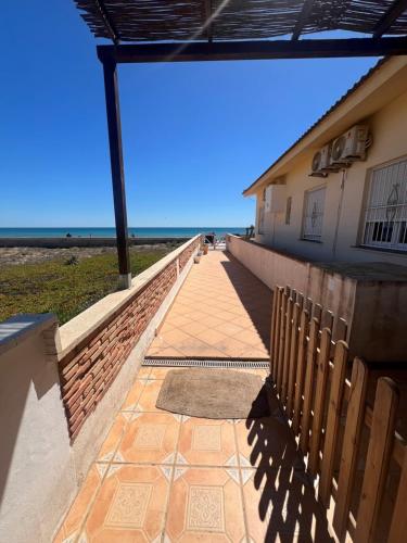 托雷维耶哈La Mata primera línea de playa的通往一座以海洋为背景的建筑的走道