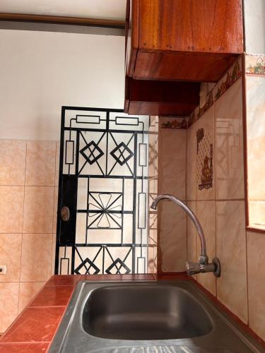 普卡尔帕ALAMEDAS APARMENTs的厨房设有水槽和瓷砖墙