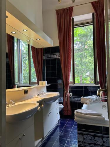 Venegono Superiore普契尼别墅度假屋的一间带两个盥洗盆和大镜子的浴室