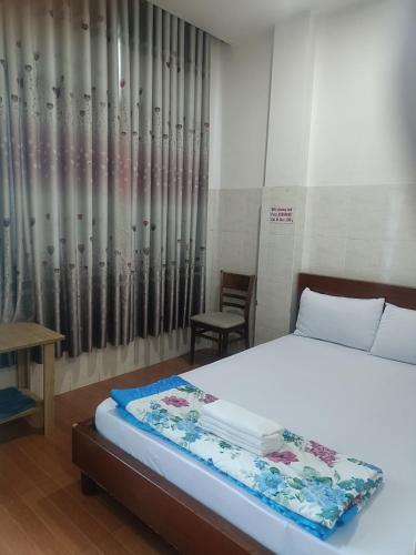 胡志明市Hotel phương linh 364 phạm hùng的卧室配有1张床、1张桌子和1把椅子