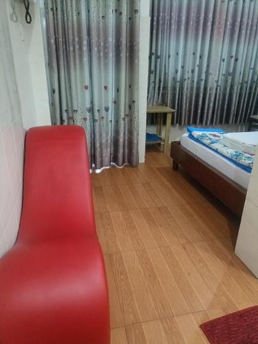 胡志明市Hotel phương linh 364 phạm hùng的一张红色椅子,位于带床和窗户的房间