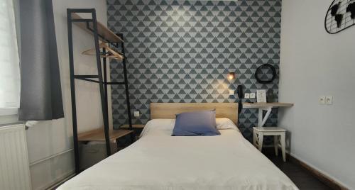 图尔圣让酒店的一间卧室配有一张带蓝色枕头的床