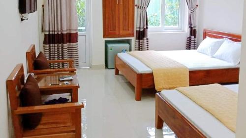 Thương Xà (2)Khách Sạn Thành Đạt的酒店客房设有两张床和一张桌子。