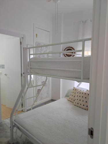 奇皮奥纳Apartamentos home Chipiona的配有梯子的小客房内的双层床