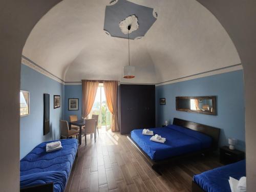 梅塔拉皮尼盖拉索伦托住宿加早餐旅馆的一间带2张蓝色床的卧室和一间餐厅