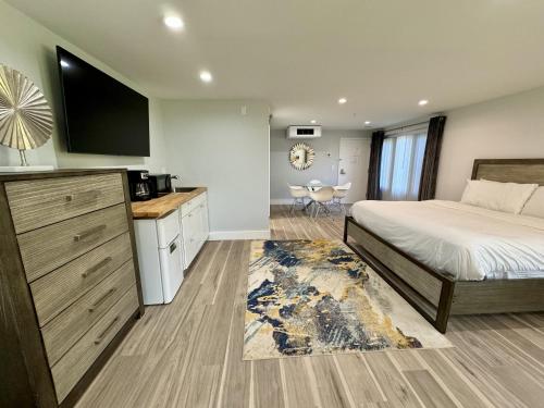 亨德森维尔SKYLARANNA Resort & SPA的一间卧室配有一张床和一台电视,还设有一间厨房