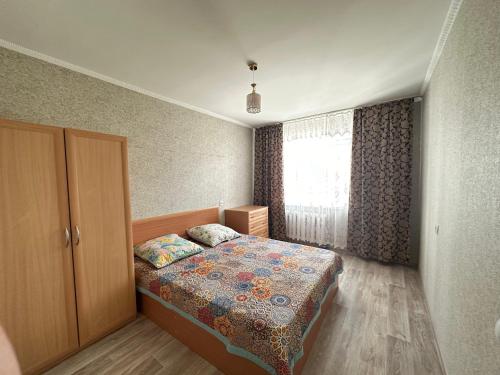 巴甫洛达尔Назарбаева 204的一间小卧室,配有床和窗户