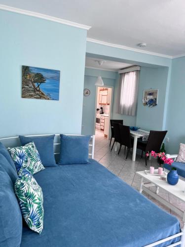 圣帕拉斯凯维Zoel's House in Chalkidiki的一间带蓝色沙发的客厅和一间用餐室
