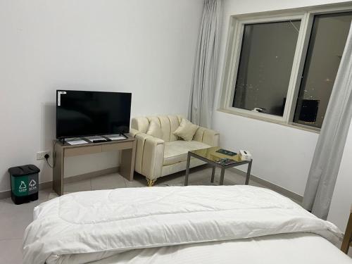 迪拜Dubai Entire Serviced Room Unit Excellence的一间卧室配有一张床、一把椅子和电视