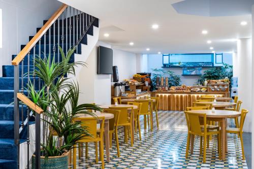 锡帕基拉卡米诺拉萨尔酒店的一间设有黄色桌椅和楼梯的餐厅