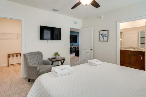 达文波特Disney Area Vacation Rental with Game Room and Pool!的一间卧室配有一张床、一把椅子和电视