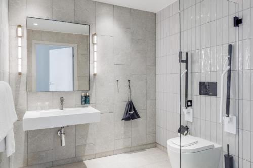 斯德哥尔摩Clarion Collection Hotel Tapetfabriken的一间带水槽、卫生间和镜子的浴室