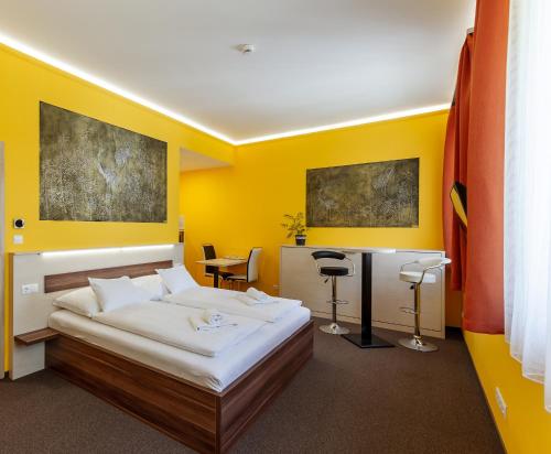 维斯普雷姆Hostel Mayer Superior Veszprém的黄色卧室配有床和书桌