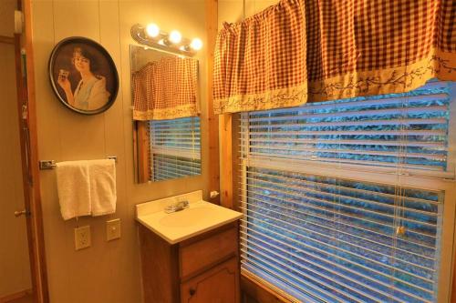 海伦Mountain Cabin in woods 3 minutes to Helen #13的一间带水槽和镜子的浴室以及窗户。