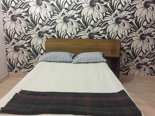 耶拉吉里Woodside Resort and Cafe的一间卧室配有一张带花卉壁纸的床