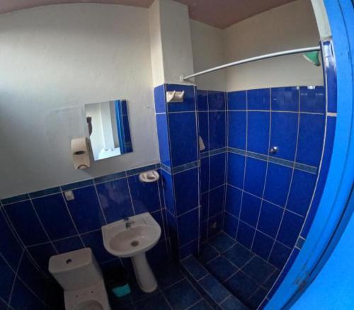 塔拉波托Hospedaje Koral的蓝色瓷砖浴室设有卫生间和水槽