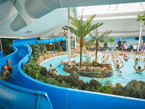 罗赫尔Child-friendly villa with large garden in Limburg的度假村游泳池的水滑梯