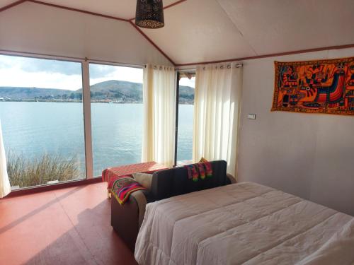 普诺Coila Titicaca lodge的一间卧室配有一张床,享有水景