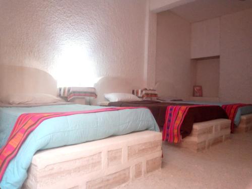 乌尤尼salt beds of salt hostal的一间卧室配有两张床和一张沙发。