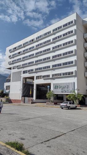 MéridaPark Hotel Mérida的前面有一辆汽车停放的白色建筑