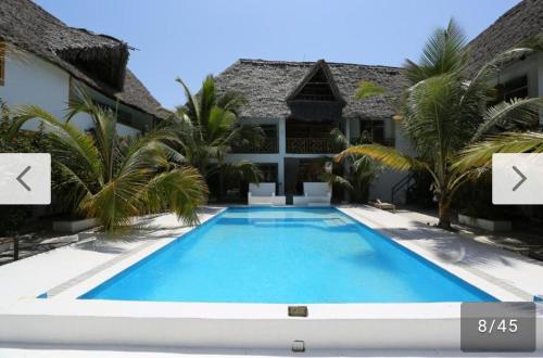 帕杰Ayras Hotel Zanzibar的房屋前的游泳池