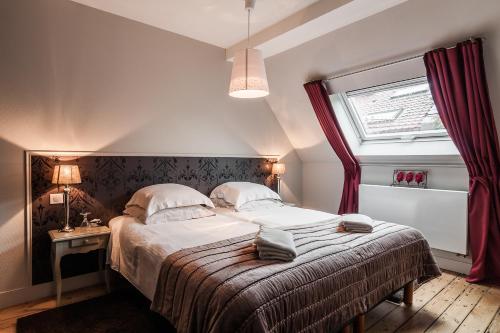 里尔香普兰旅馆 - 住宿加早餐旅馆的一间卧室设有一张大床和一个窗户。