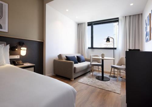 马拉加Hotel Málaga Alameda Centro Affiliated by Meliá的一间卧室设有一张床和一间客厅。