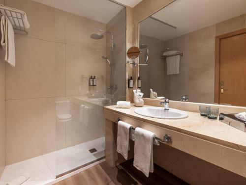 马拉加Hotel Málaga Alameda Centro Affiliated by Meliá的一间带水槽、淋浴和镜子的浴室