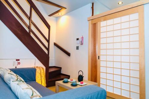 京都西半度假屋的客厅设有蓝色的沙发和楼梯。