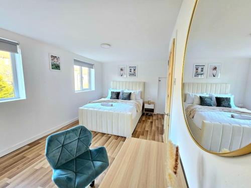 格拉斯哥Spacious Haven with Free Parking的一间卧室配有两张床、镜子和椅子