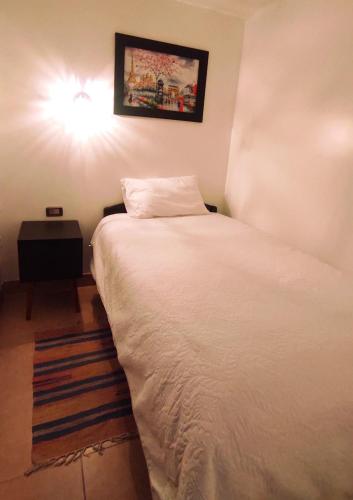 安达韦拉斯ANDAHUAYLAS CENTRO的卧室配有白色床,墙上有灯