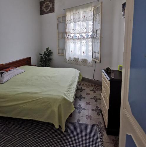 突尼斯Dar Mima Baya的一间卧室配有一张床、一个梳妆台和一扇窗户。