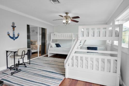 珊瑚角SW Florida Retreat的卧室配有白色双层床和书桌