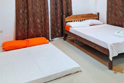 卢纳将军城RedDoorz @ Hergem Siargao Inn的配有橙色床单的客房内的两张床
