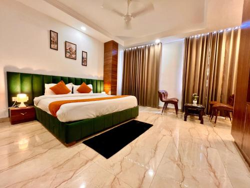 贾姆讷格尔Sanklap Hotel的一间卧室配有一张大床和绿色床头板