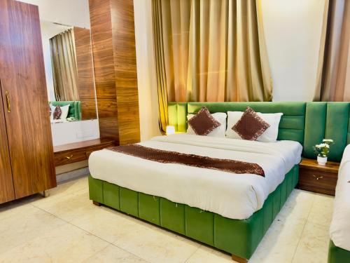 贾姆讷格尔Sanklap Hotel的一间卧室配有一张大床和绿色沙发