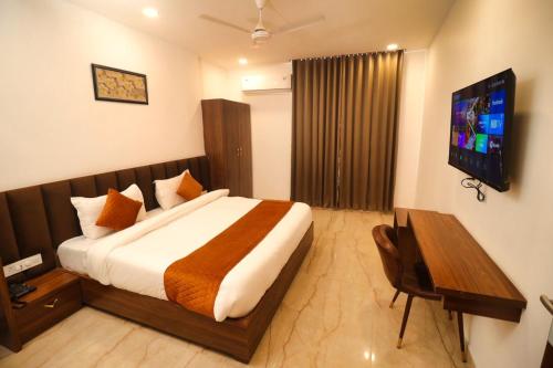 贾姆讷格尔Sandhu Lodge的酒店客房,配有床和电视