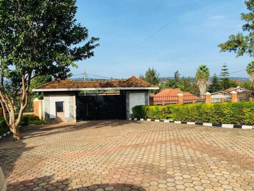 基加利Quiet and Spacious Hidden Gem in Kigali with Breathtaking Views right by the Airport的房屋前有砖车道的车库