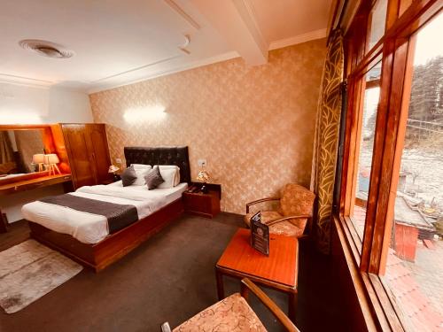 贾姆讷格尔Happy Valley INN的酒店客房设有床和窗户。