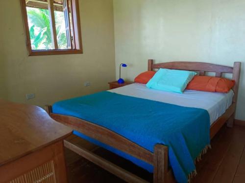 巴斯蒂门多斯Casa Ylang的一间卧室配有蓝色和橙色枕头的床
