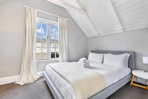 奥克兰Beautiful Ponsonby Villa的一间卧室设有一张大床和一个窗户。
