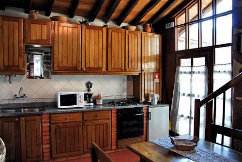 ValezimCasa do Forno的厨房配有木制橱柜和白色微波炉