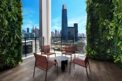 吉隆坡Luxury Continew Residence with KLCC,TRX,Ikea View的大楼内带桌椅的阳台