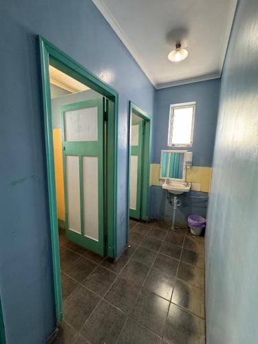 艾尔Ayr Budget Accommodation的浴室设有绿门和水槽